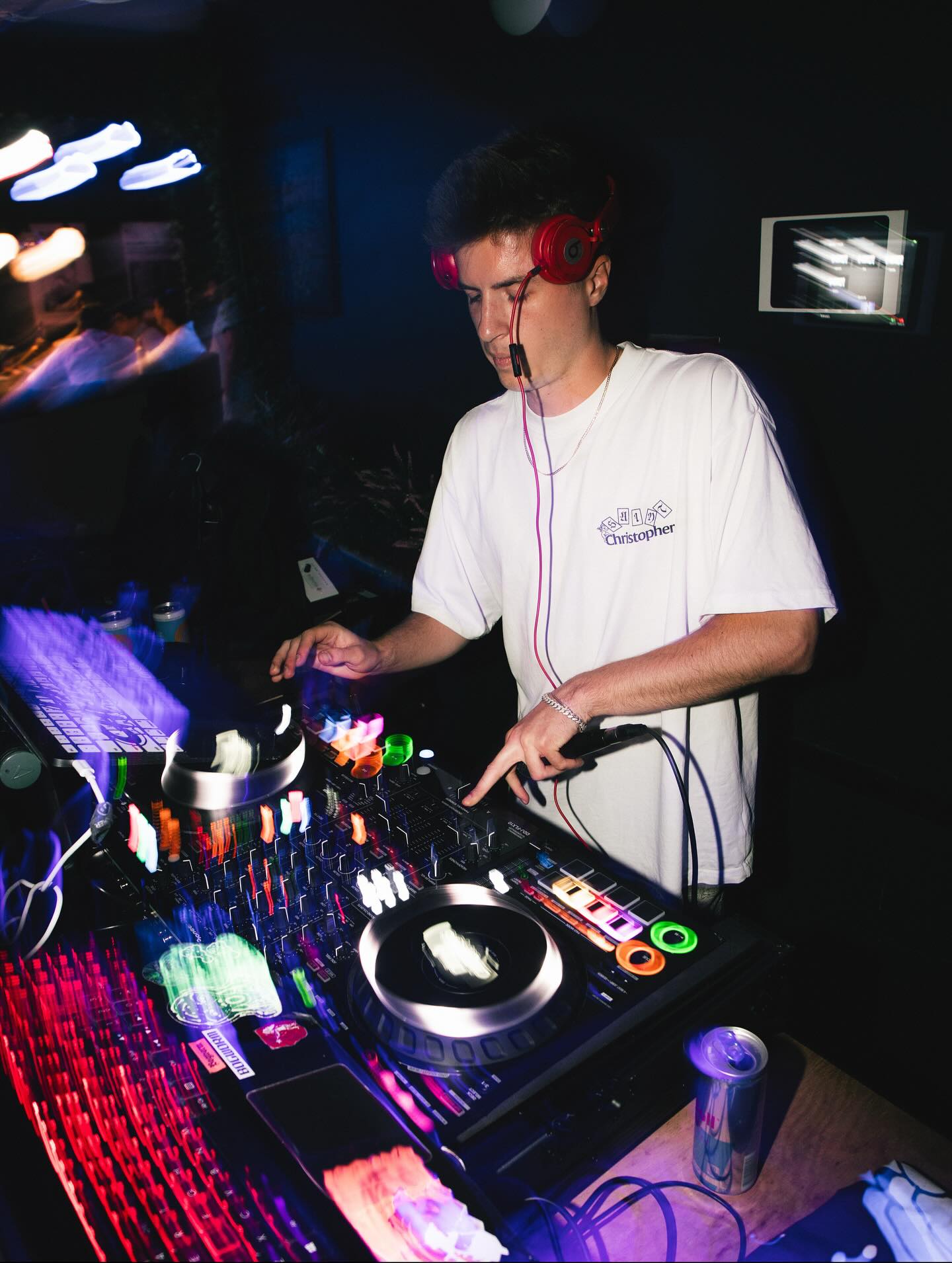 DJ Chris G performing live on a Pioneer controller under colorful club lights
