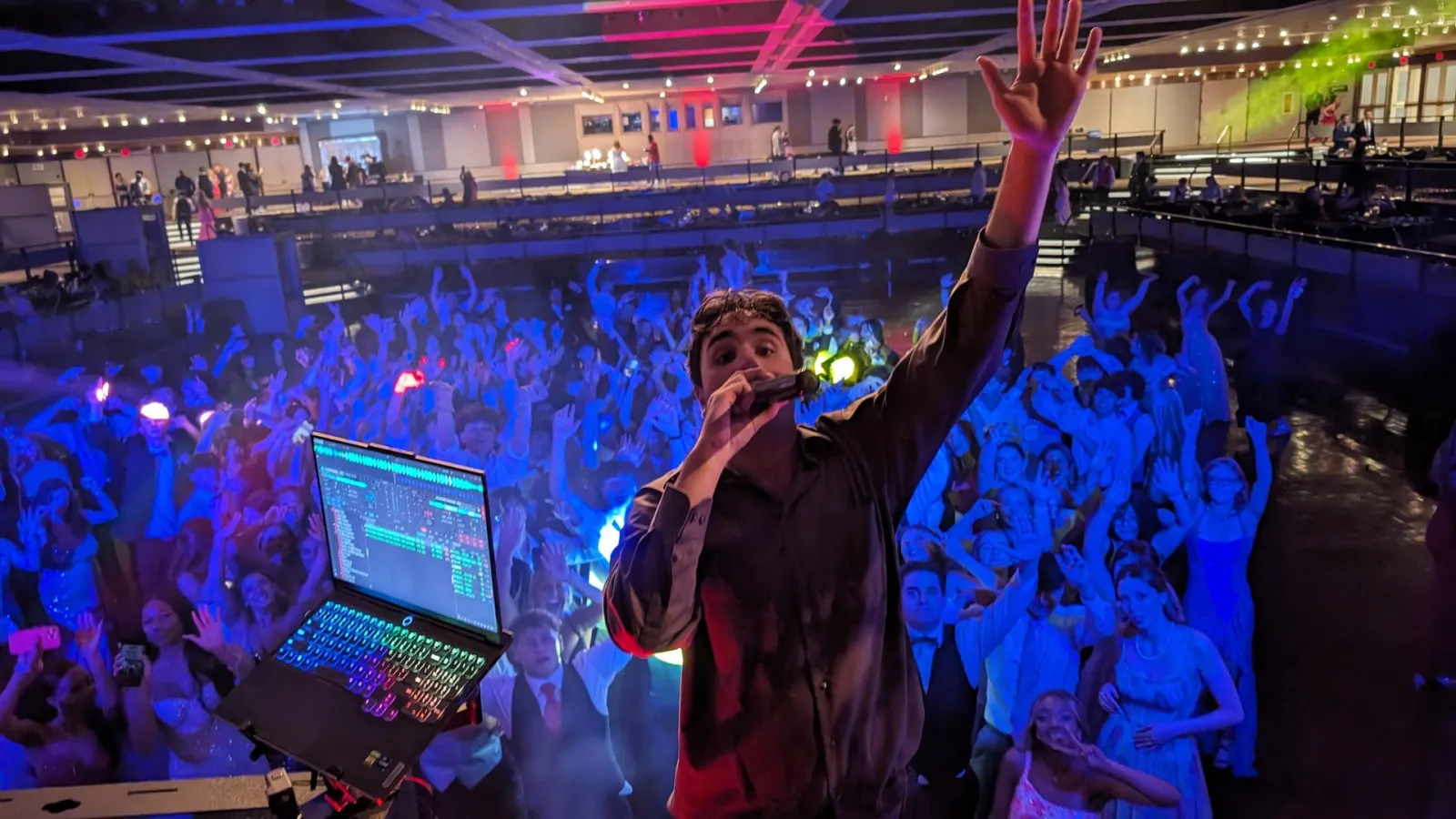 NWN DJ on the mic hyping a packed prom crowd from the DJ booth