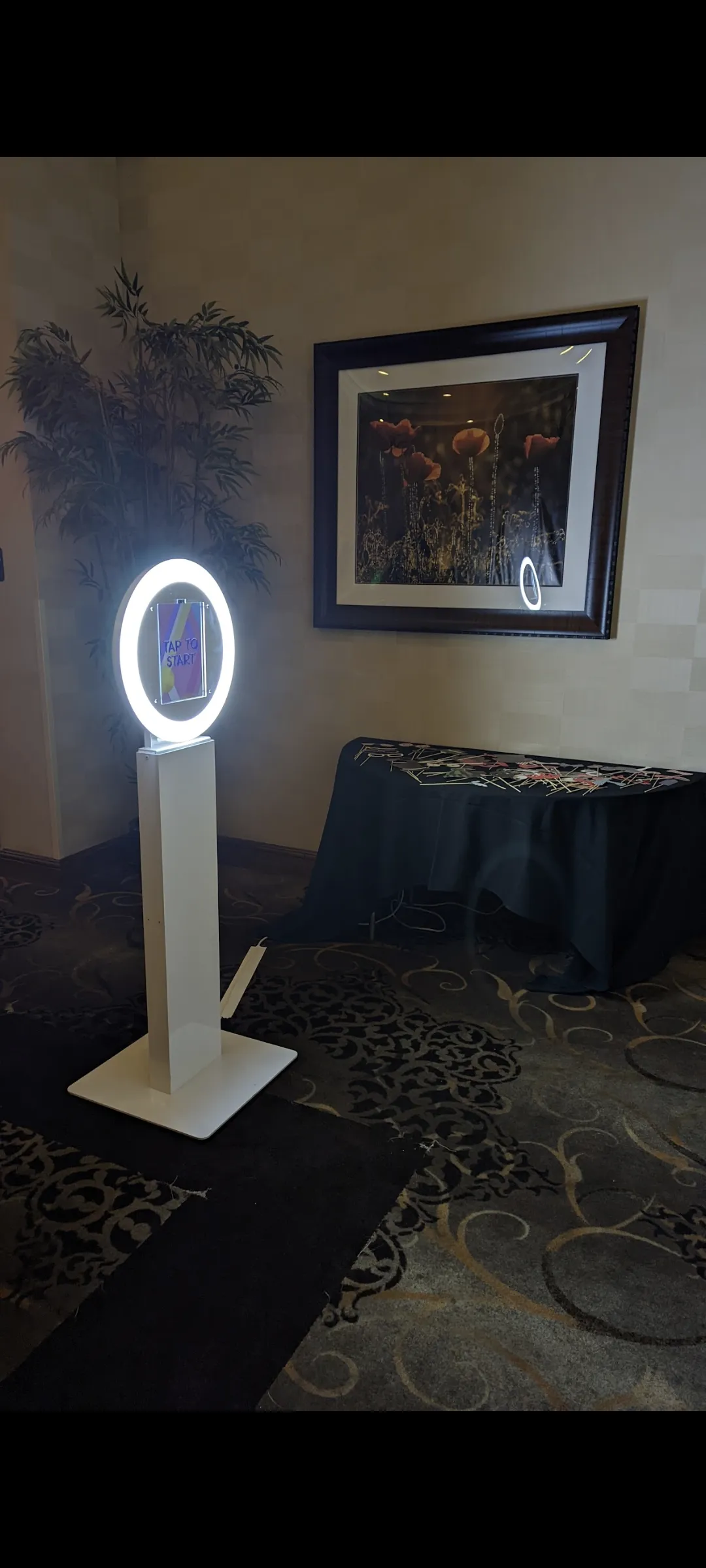 Sleek open-concept NWN photo booth with a glowing ring light in a hotel event space